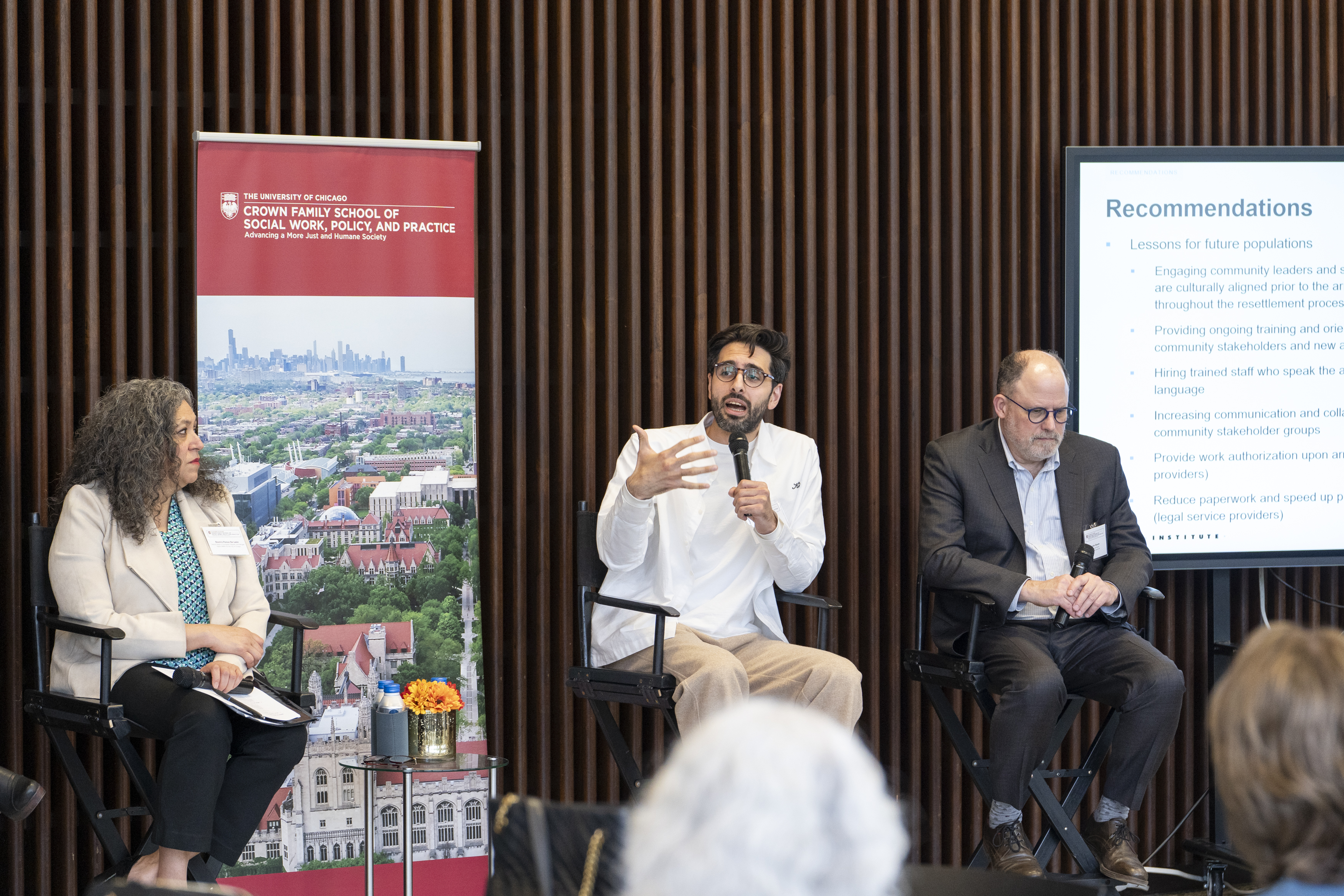 image of man in white shirt holding a microphone sitting on with other panelists