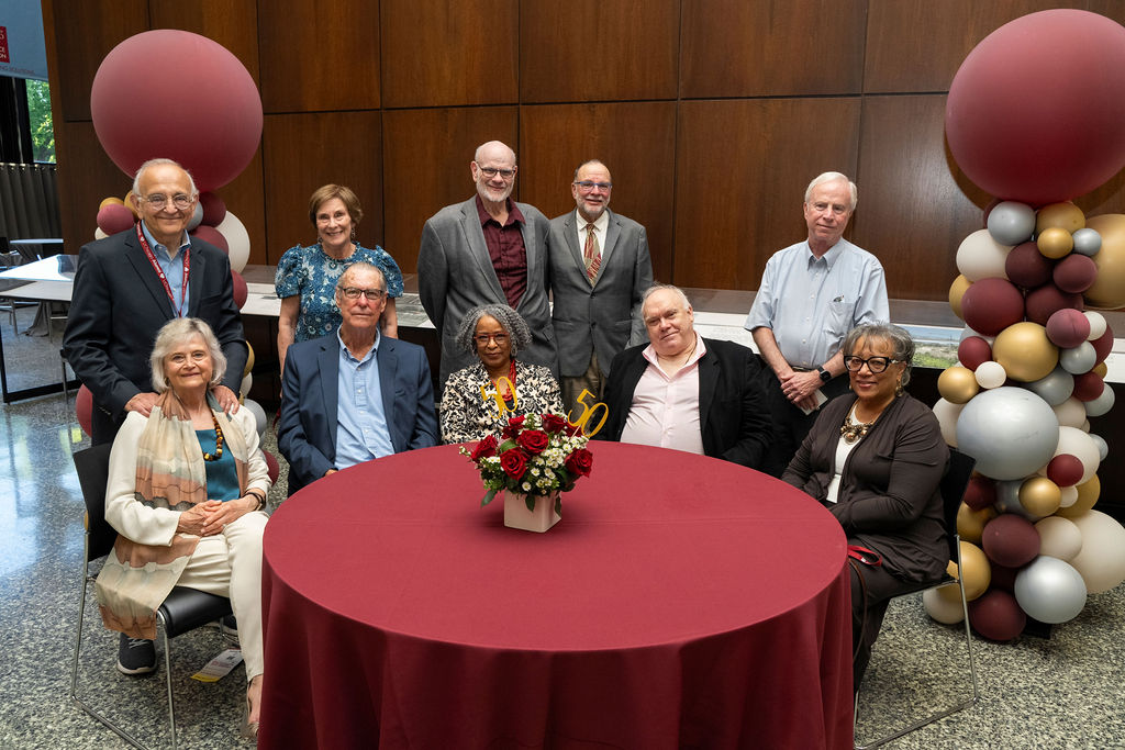 Group of people seated and standing for a photo