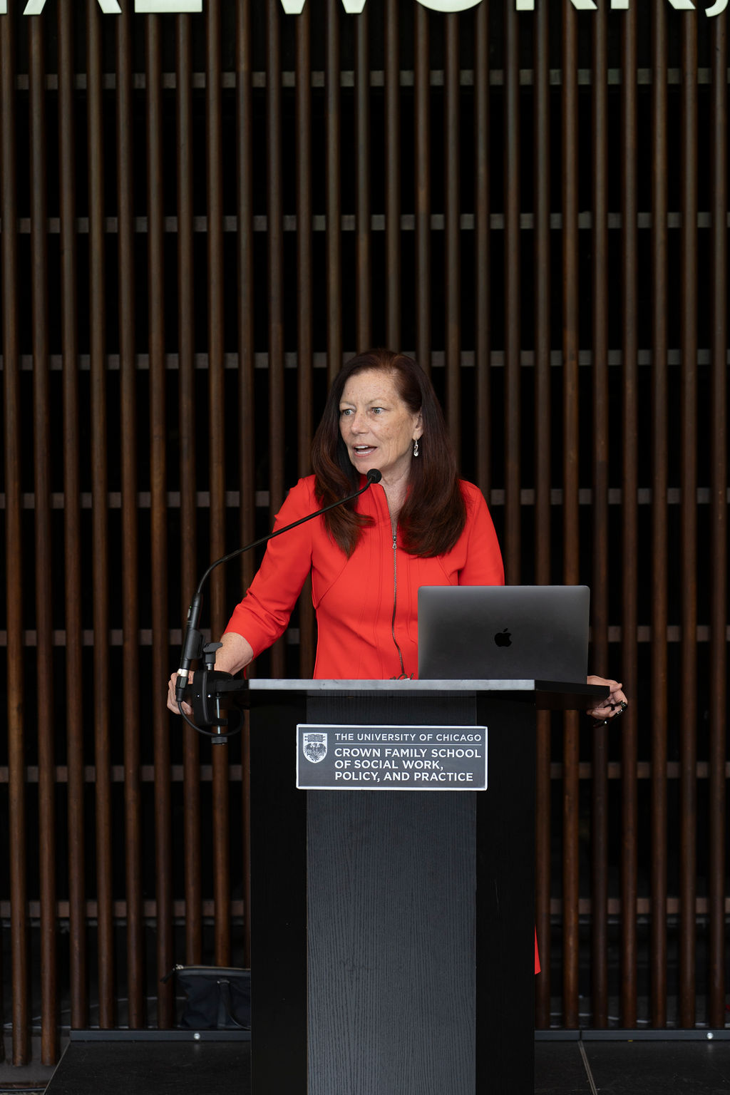 Woman standing at podium in orange dress