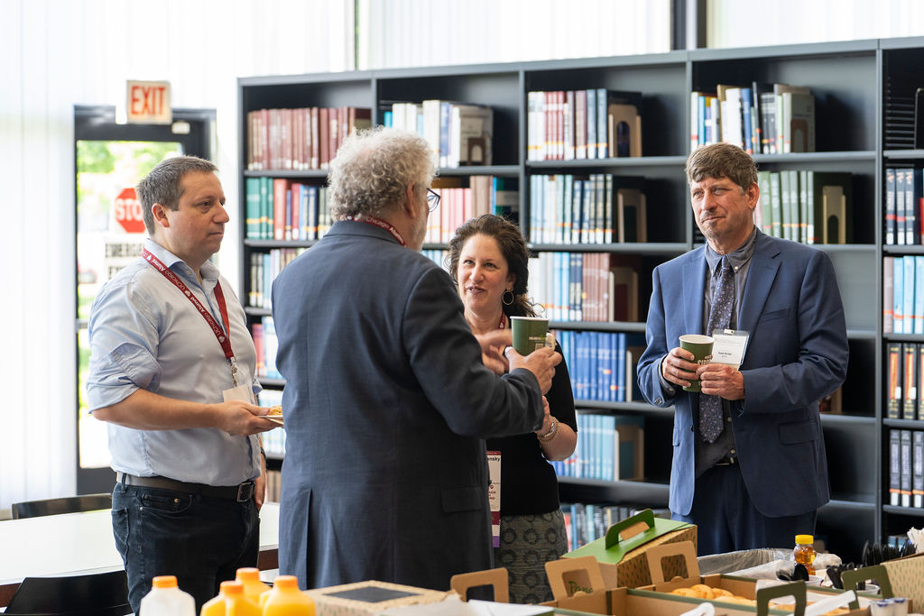 Four Alumni standing talking during networking brunch