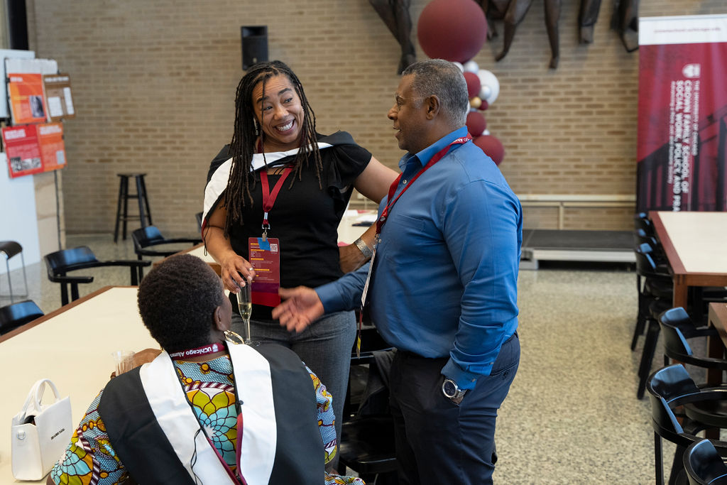 Man in blue shirt chatting with a woman in a black shirt and grey pants 