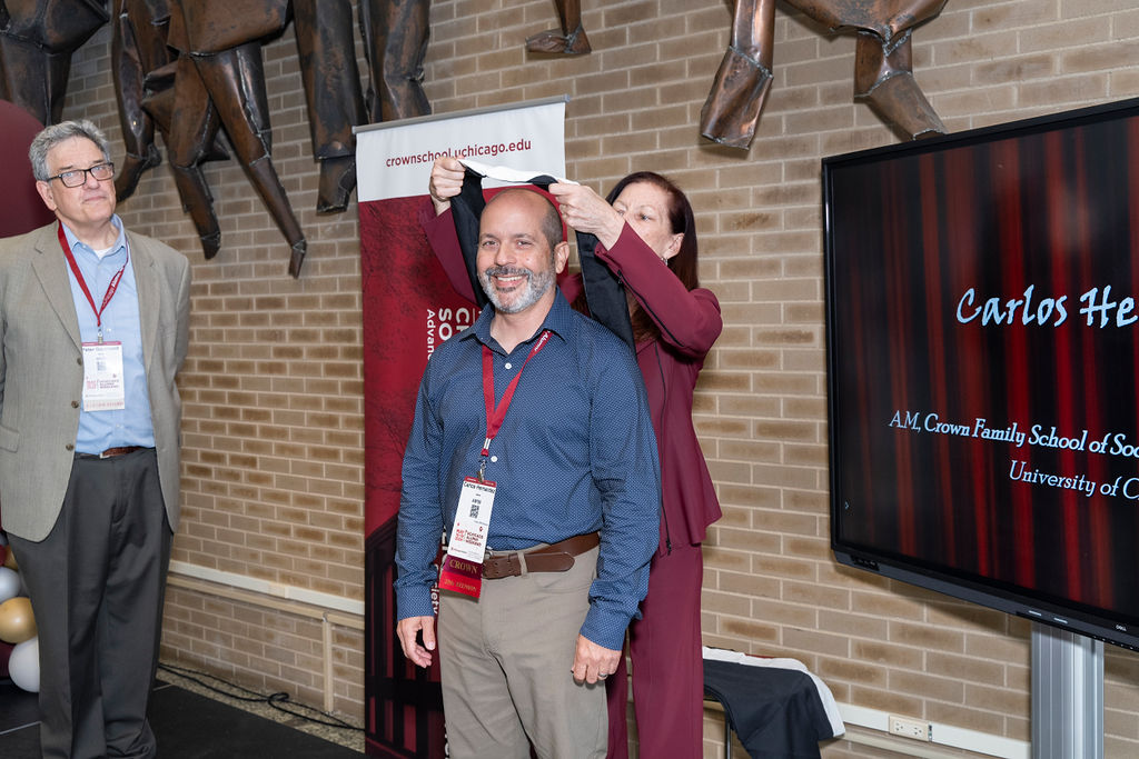 man in blue shirt with khaki pants is hooded by a woman in a maroon pant suit