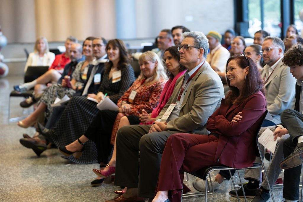 group of people in an audience listening to a speaker