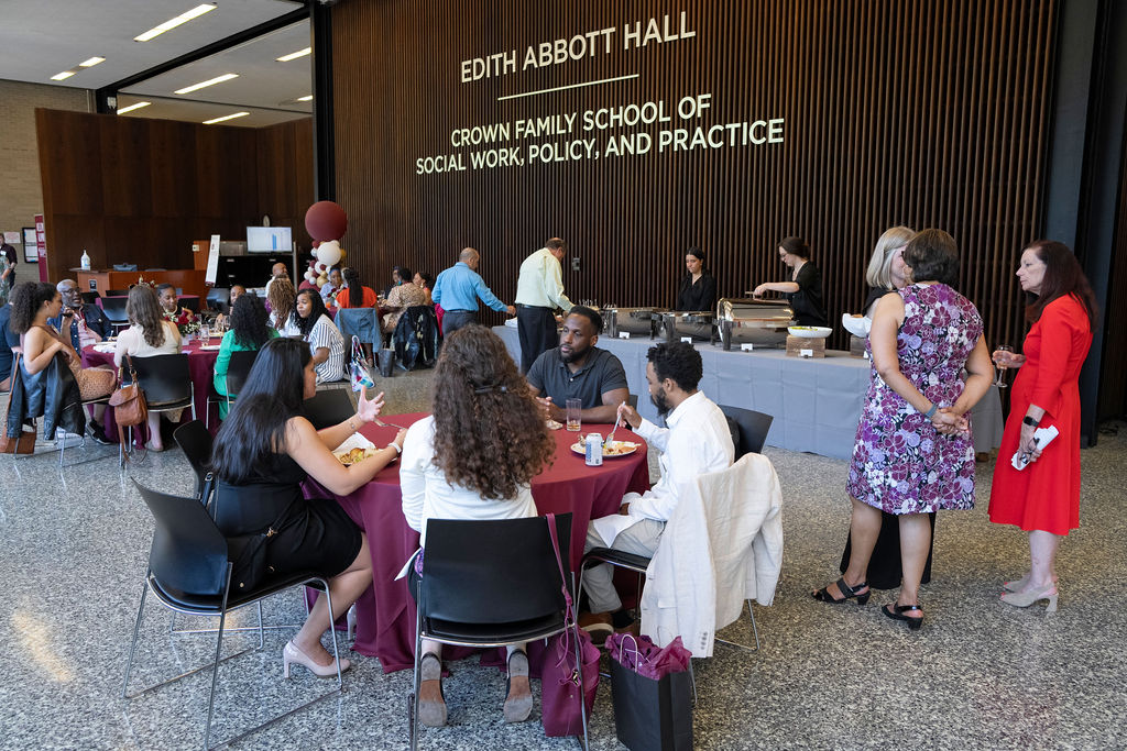 The photo show several people sitting at round tables during a dinner reception