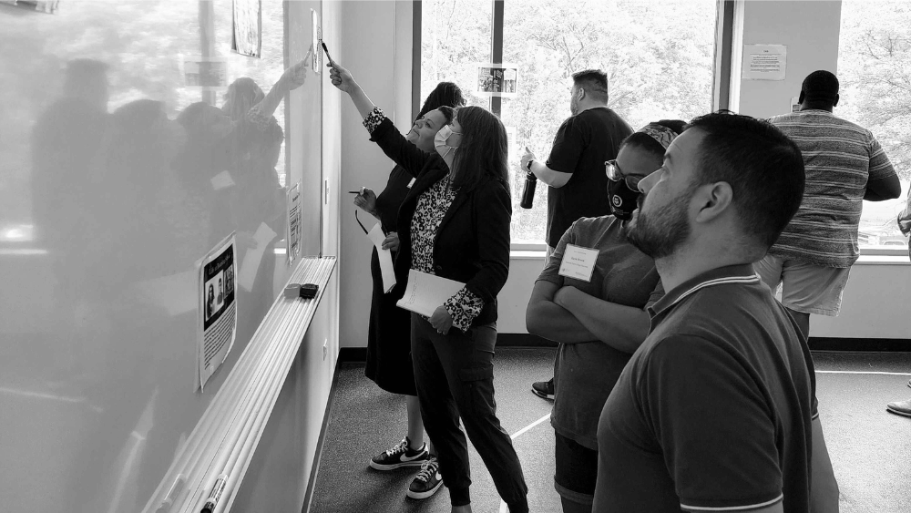 a group of people looking at a white board collaborating 