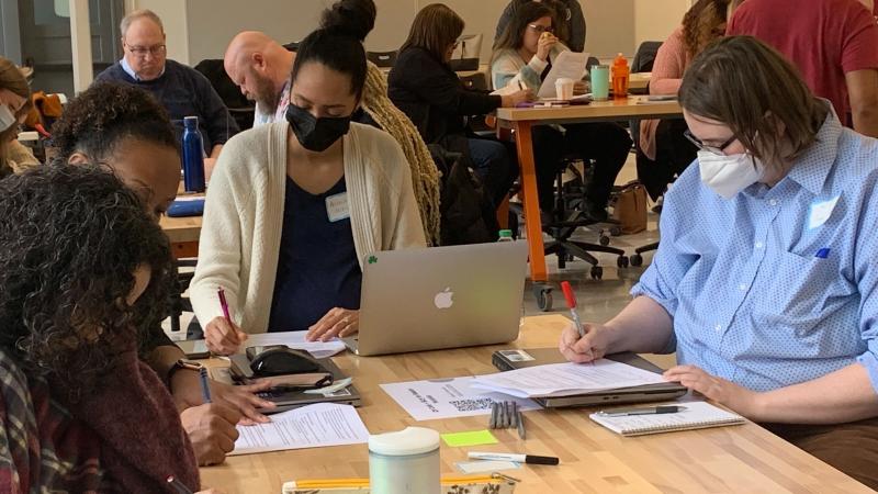 image of group of people sitting at a table working together