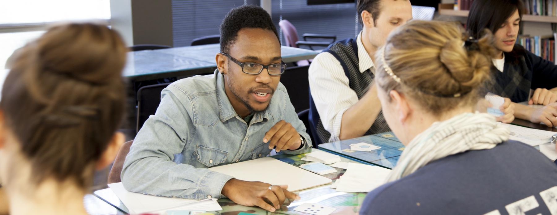 image of a guy sitting at a table with a group