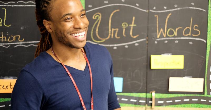 image of a guy in a blue shirt in front of a chalk board