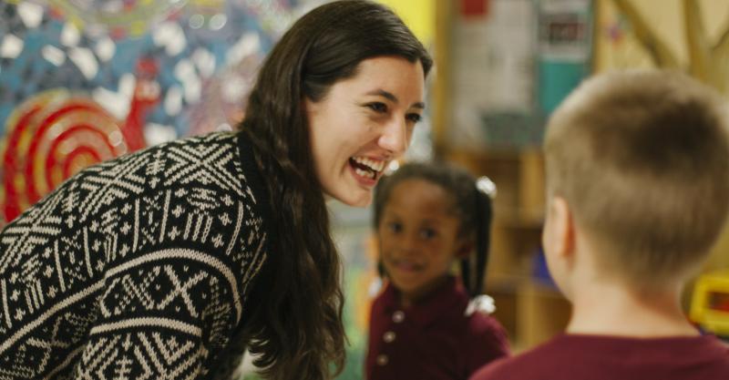 image of a woman smiling chatting with two children