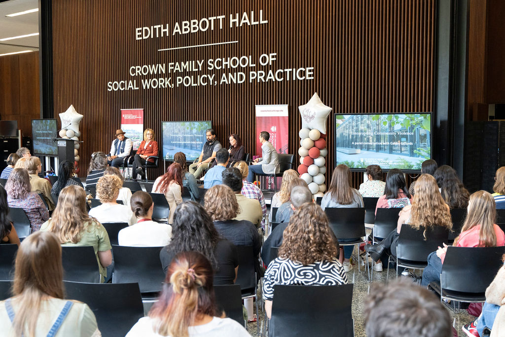 image of a panel chatting with a full audience