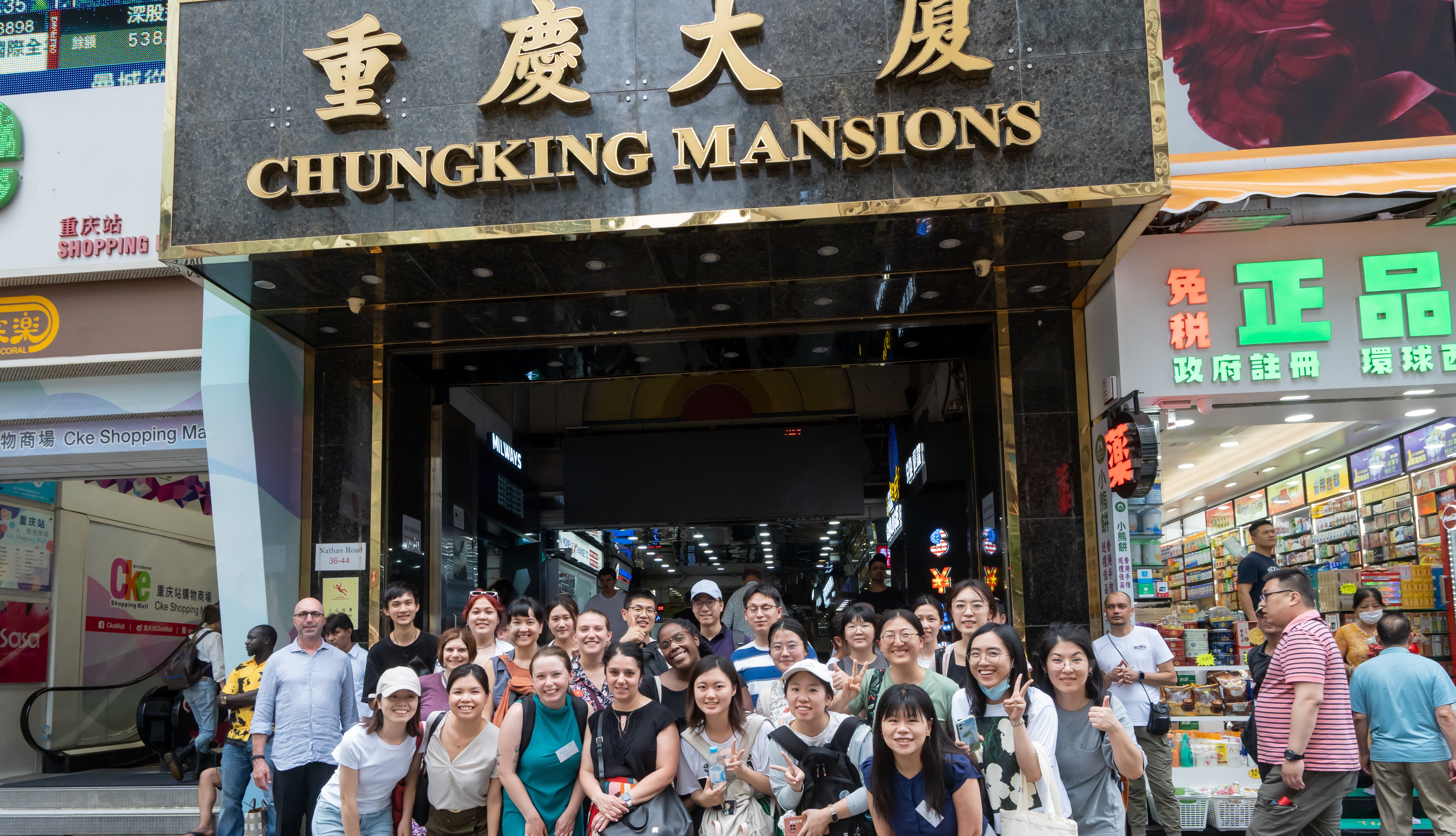 Group of Students standing smiling in front of a sign