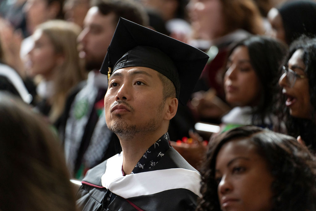 A graduate looks intently forward during the hooding ceremony.