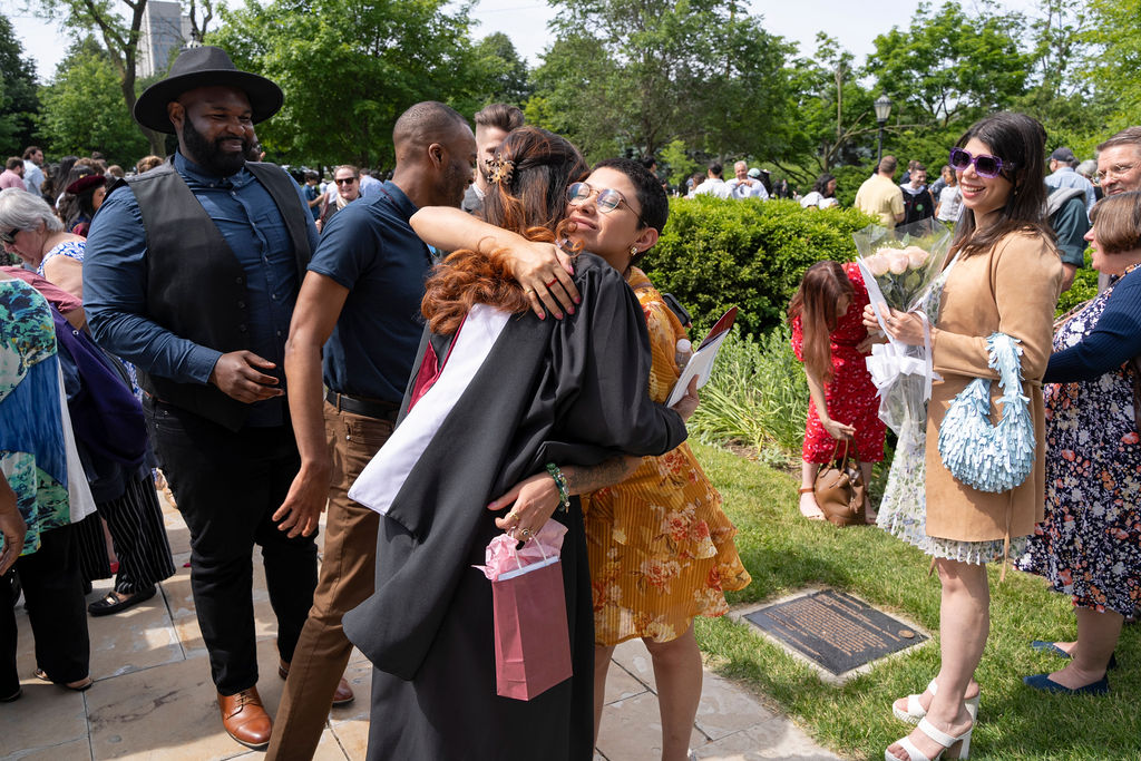 Graduate embraces loved one following the hooding ceremony