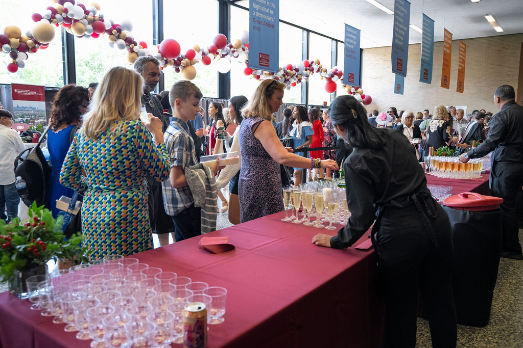 Reception following hooding ceremony gets underway as attendees get drinks and food 