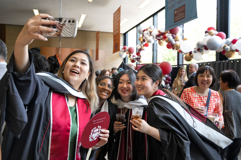 Reception following hooding ceremony gets underway as graduates take photos with one another and enjoy food and drinks 