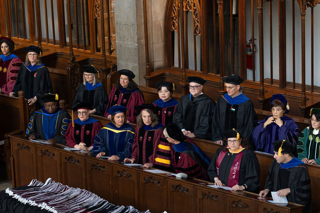 Faculty members dressing in academic regalia assemble in Rockefeller Chapel for hooding ceremony