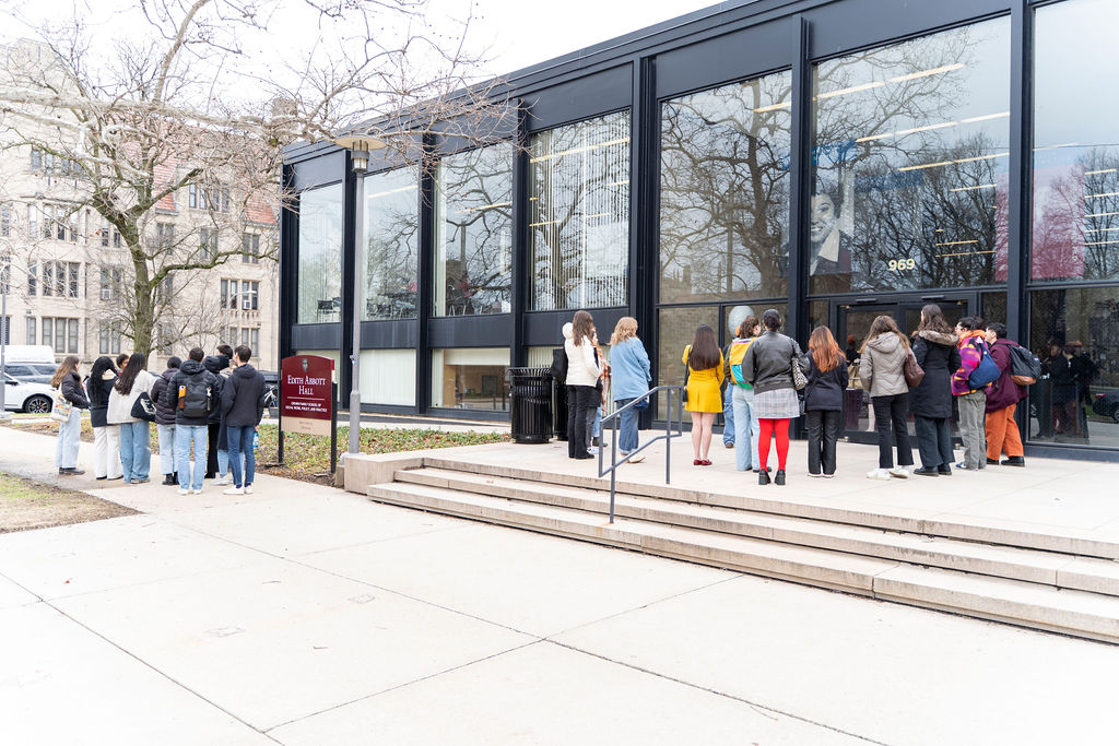 Two groups of students standing outside of the Crown School