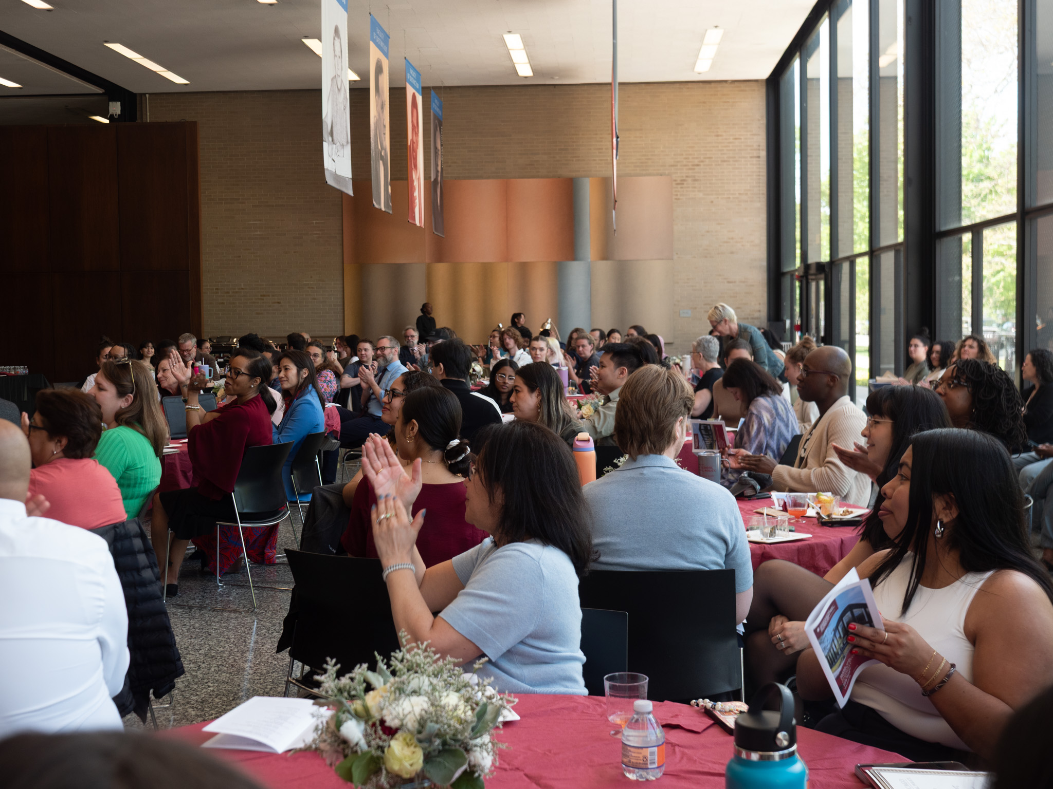 audience members listening to speaker and clapping 