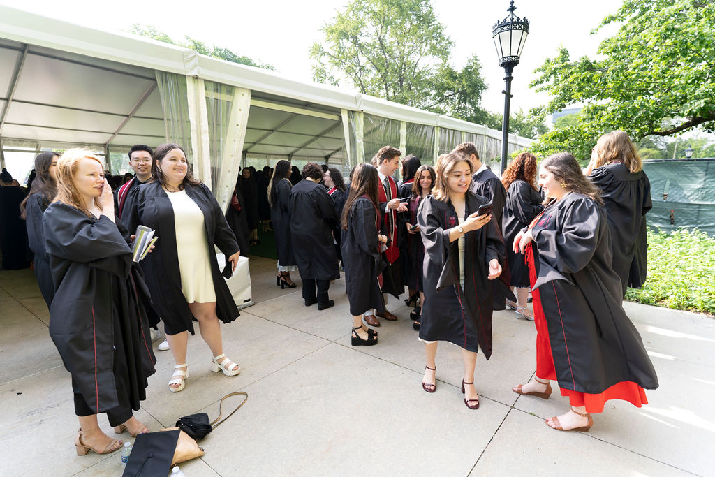 group of graduates in regalia sharing exchanges