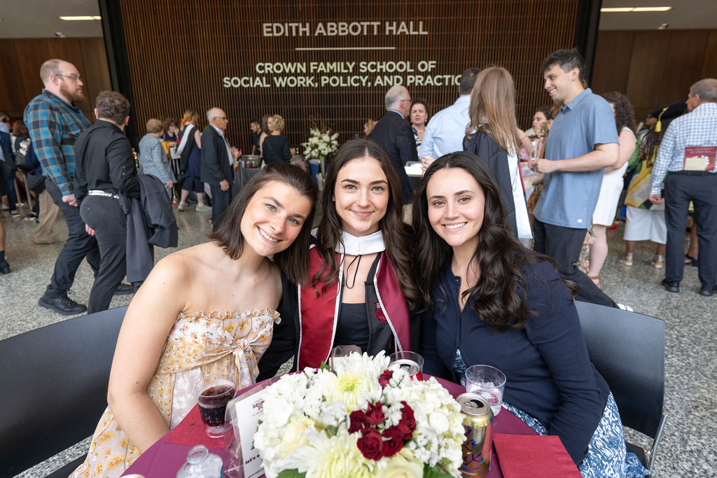 Three women sitting around a table smiling