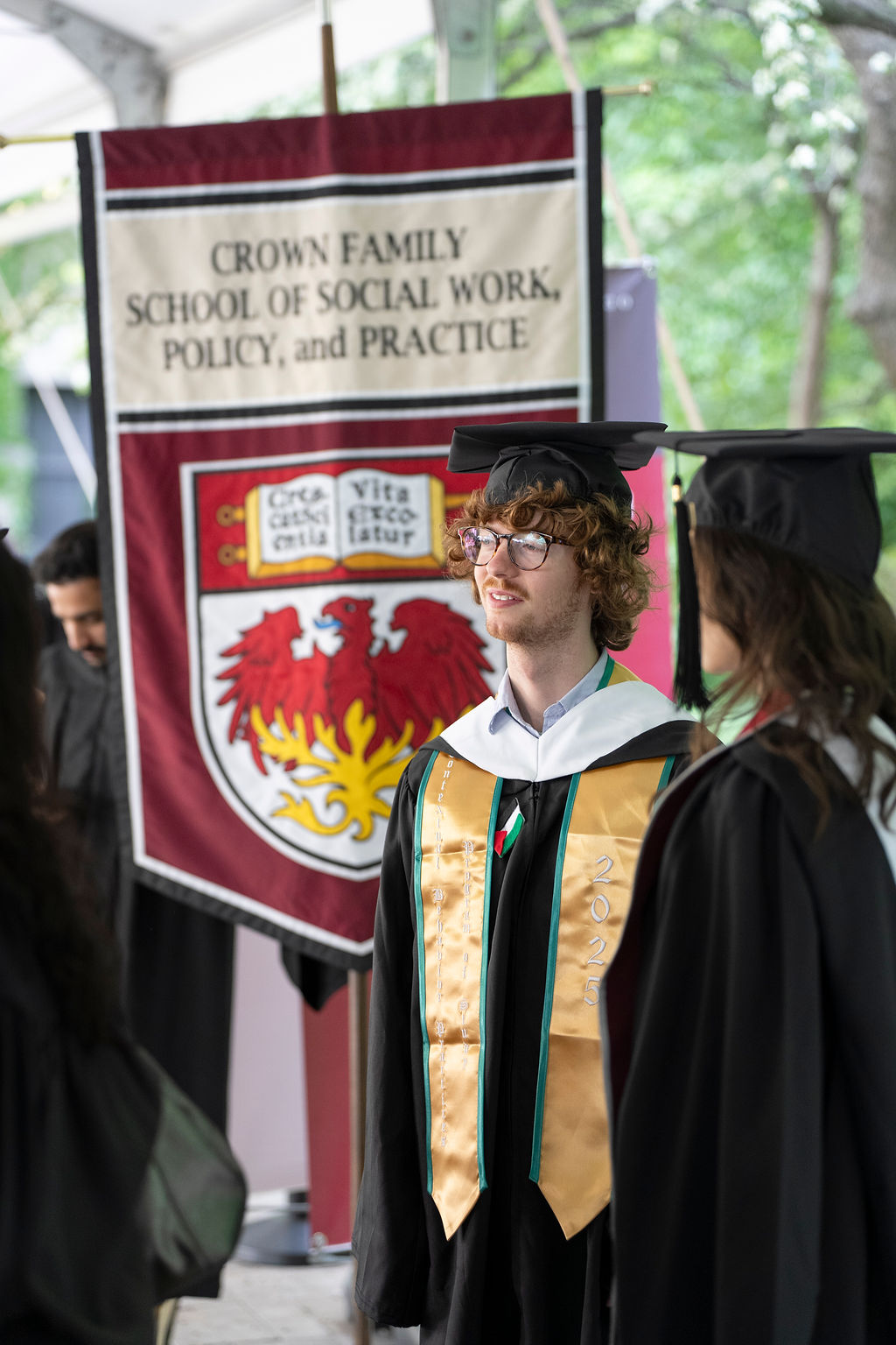 Man stanfing in front of flag
