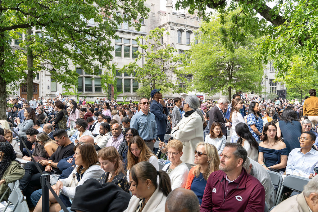 image of group of people sitting watching the convocation outdoors