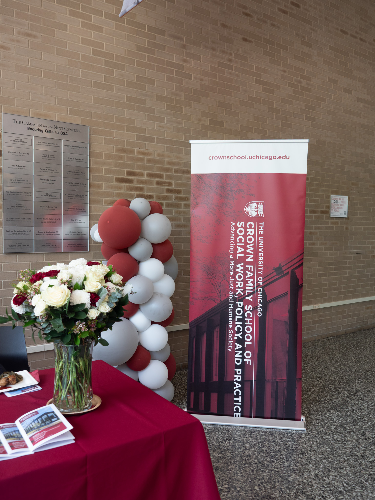 Image of pull up banner with Crown Family School logo with flowers and balloons