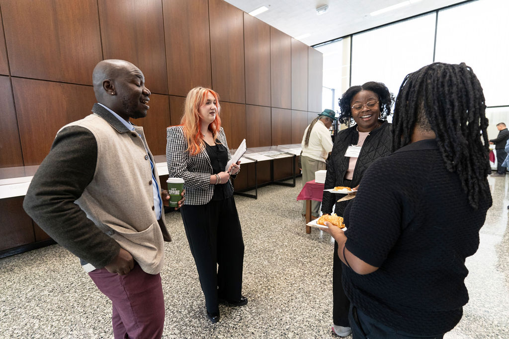 a group of people standing in a circle chatting and networking