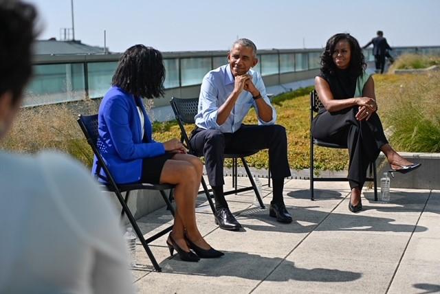 President Barack Obama and First Lady Michelle Obama speak with a scholar