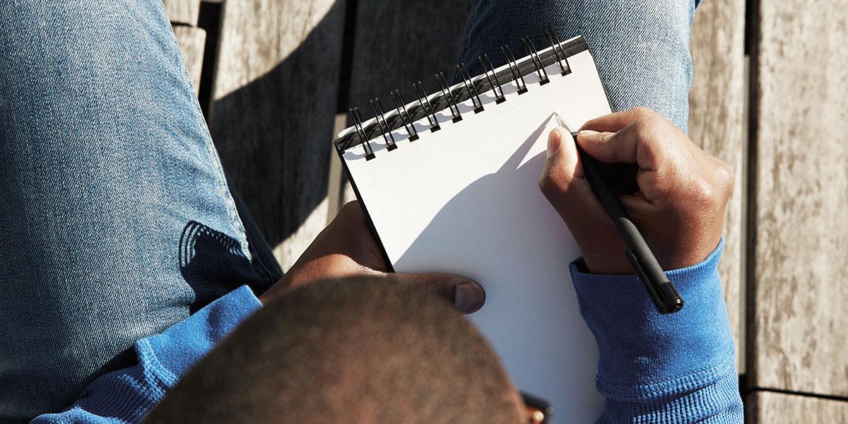 Little boy writing in a notebook