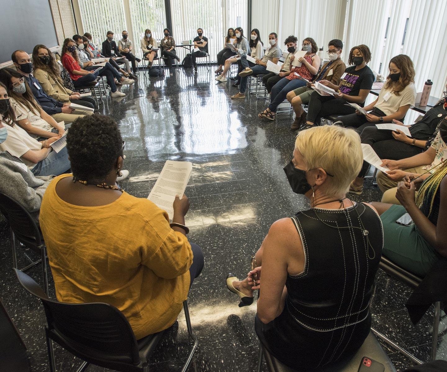 A class of students sitting in a circle, some wearing masks