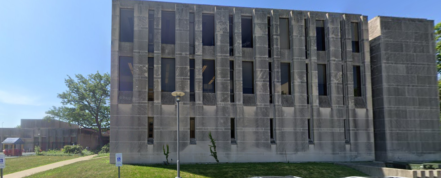 Image of building with grass and playground. 