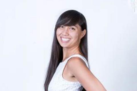 Woman in white dress with black hair smiling