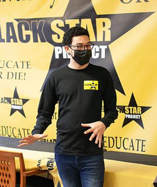 Justin Douglas speaking with community members at a Black Star Project event