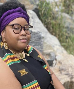 woman with glasses and purple headwrap looking