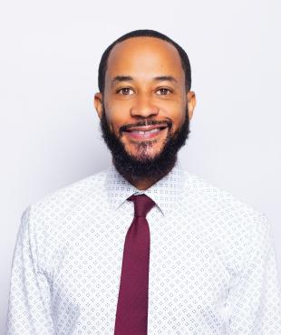 Black man wearing red tie smiling for headshot