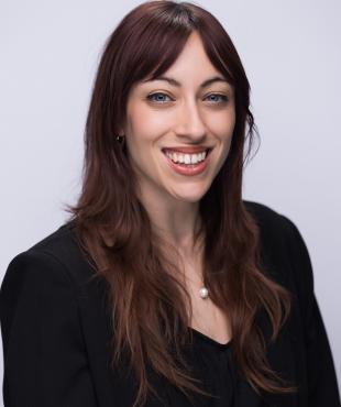 Woman with brown hair wearing black smiling