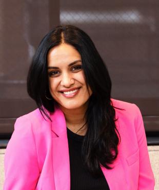 Woman in pink blazer smiling for headshot