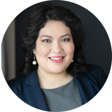 Woman in blue jacket and grey top smiling