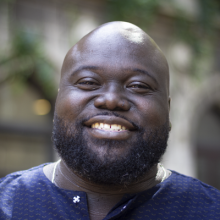 man in blue shirt with beard smiling