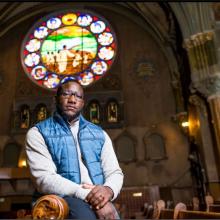 man in blue vest with white shirt in a church