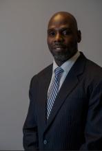 Man in dark suit with striped tie and blue shirt