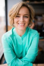 Headshot of a woman with blonde hair wearing a turquoise shirt.