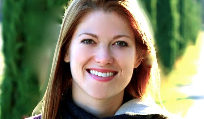 Woman with red hair smiling outdoors 